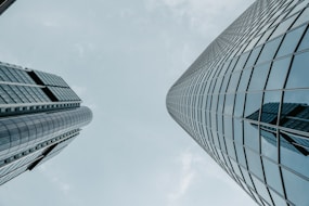 looking up at two tall buildings in a city