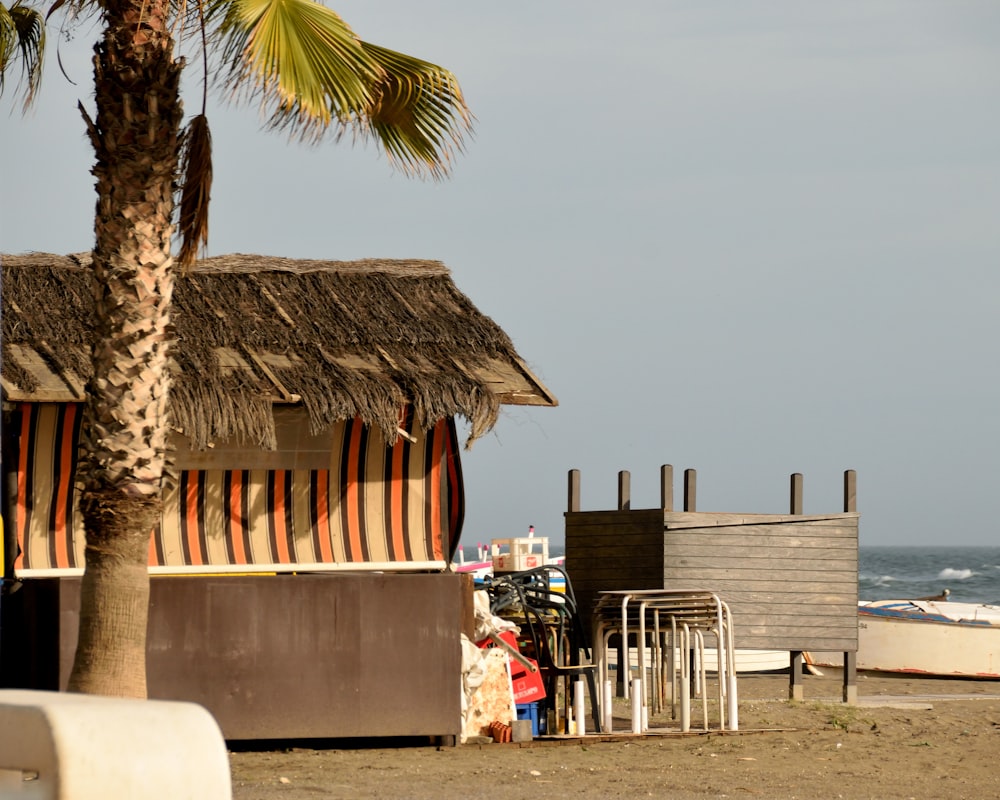 a hut with a thatched roof on the beach