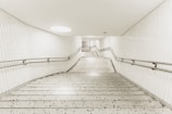 Wide shot of a spotless, freshly cleaned stairwell with polished handrails and bright lighting.