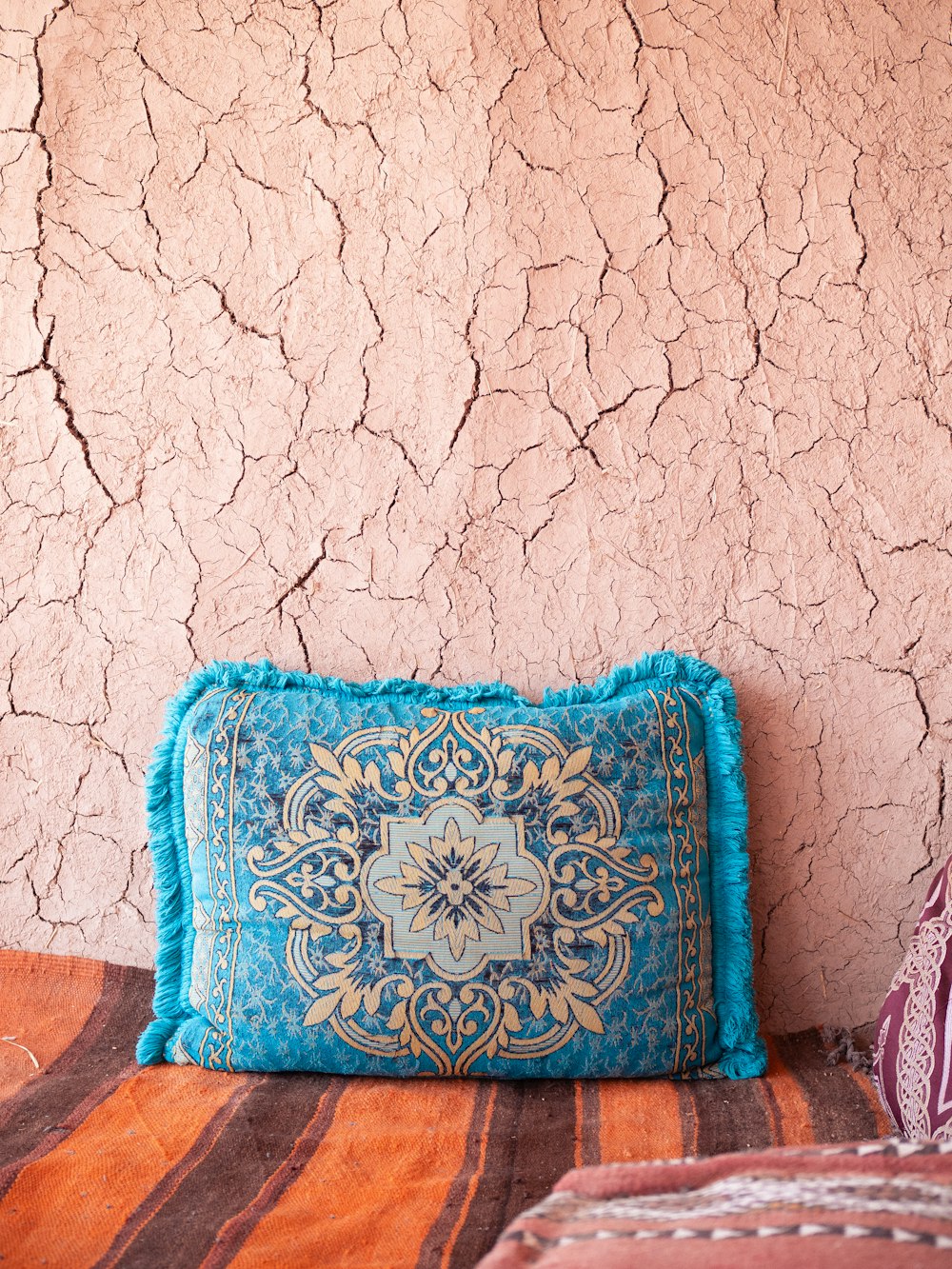 a blue pillow sitting on top of a bed