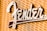 A close-up view of a metallic logo attached to a textured fabric background. The logo features a stylized font in a shiny metallic finish.