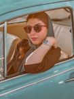 a woman wearing sunglasses sitting in a car