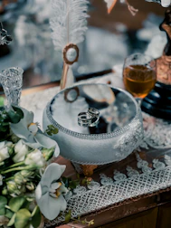 A selection of elegant wedding rings arranged on a wooden table with delicate flowers.