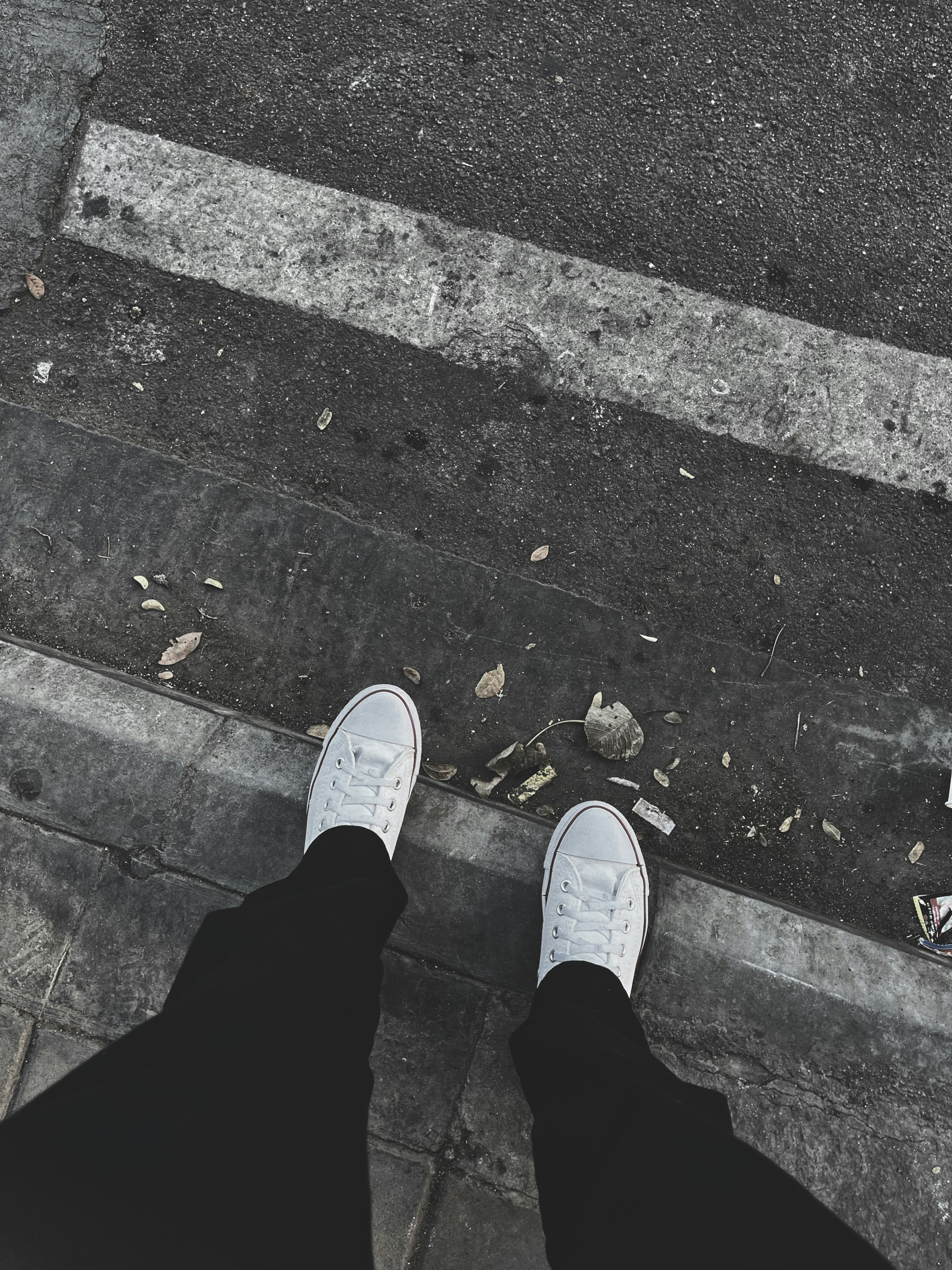 a person standing on a sidewalk next to a curb