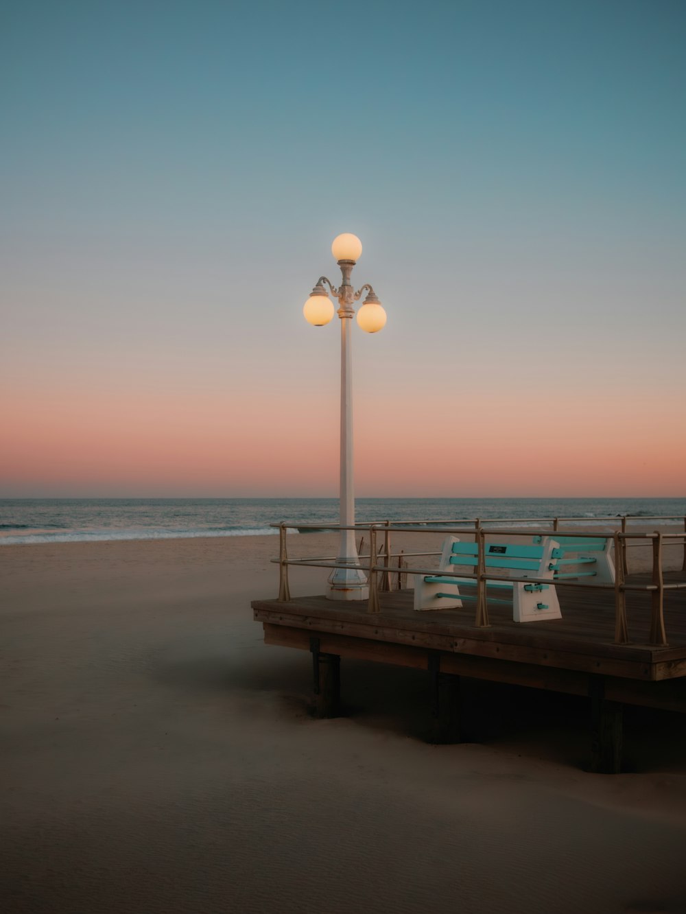 a light pole sitting on top of a pier next to the ocean