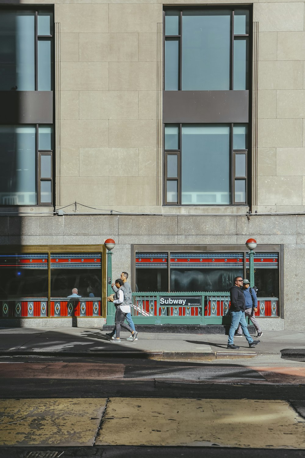 a group of people crossing a street in front of a tall building