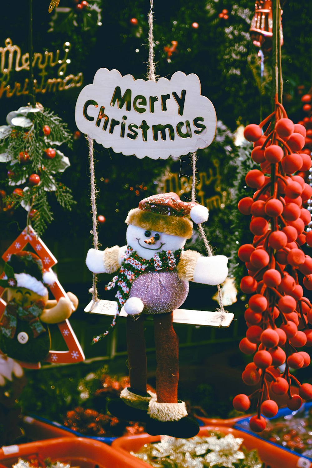 a merry christmas sign hanging from a tree