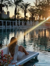 a woman sitting on the edge of a swimming pool