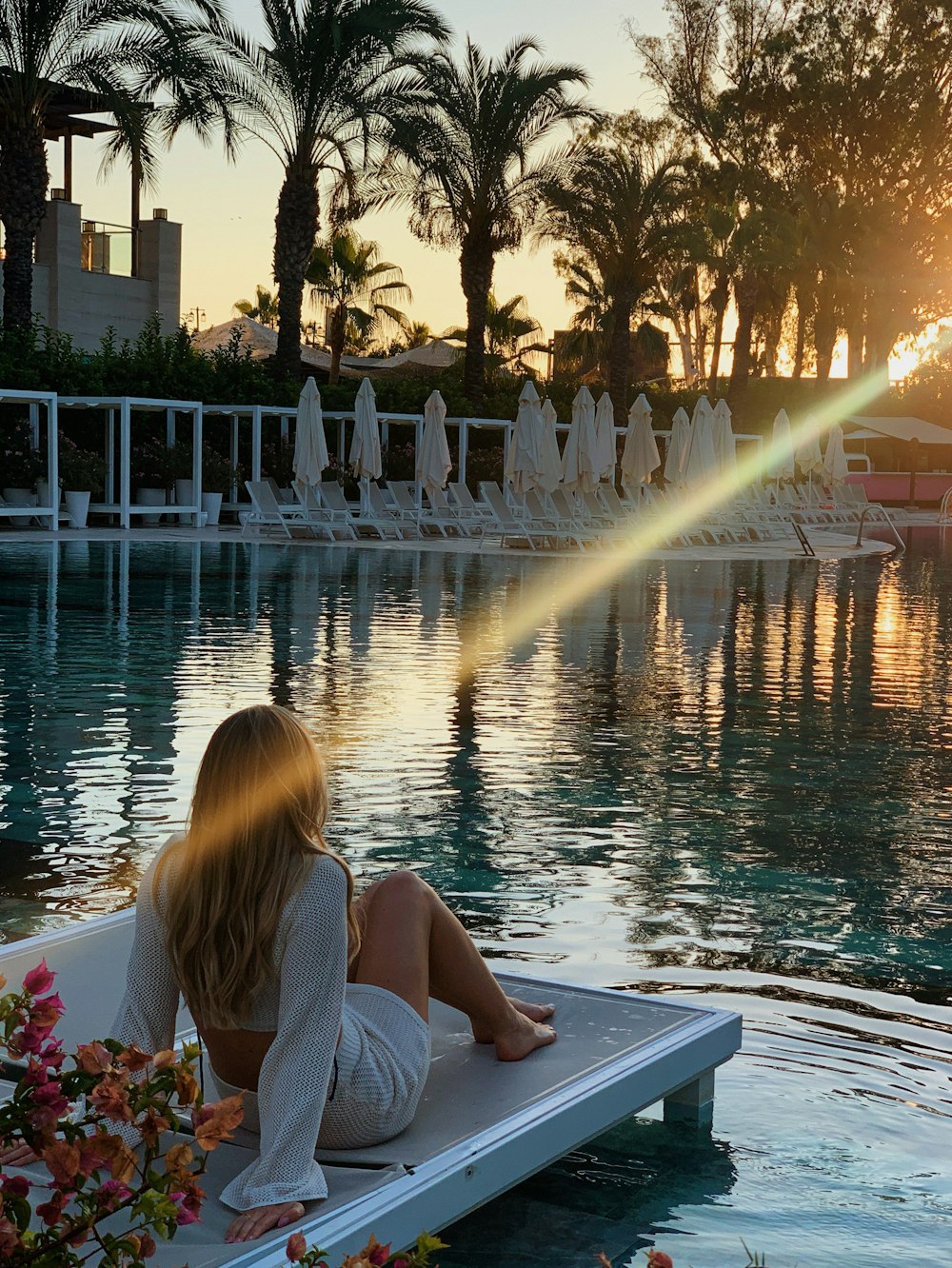 a woman sitting on the edge of a swimming pool