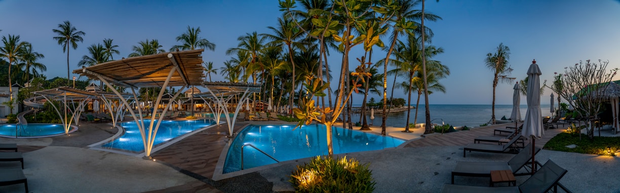 A tranquil beachfront view at sunset with the resort’s pool overlooking the ocean.
