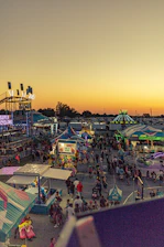 A colorful, dynamic festival scene featuring Carnivilla's interactive art installation glowing at dusk.