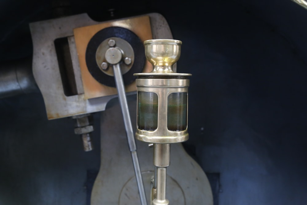 um close up de um objeto de metal com uma máquina em segundo plano