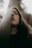 A person with closed eyes leans against a textured vertical surface, creating a tranquil and introspective atmosphere. The textured surface partially obscures the face, and soft, natural lighting enhances the serene mood.