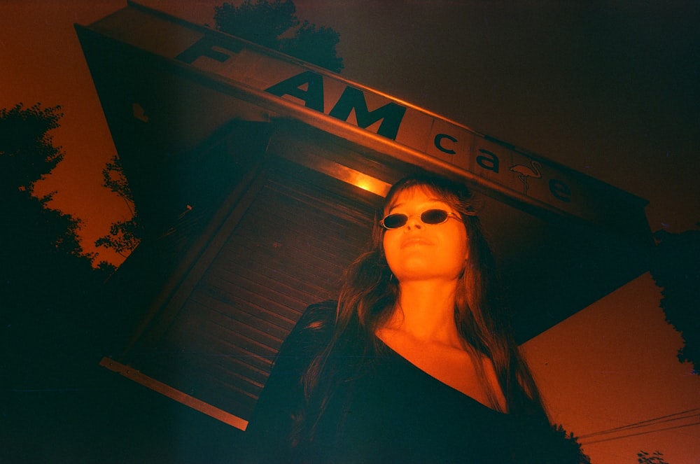 a woman wearing sunglasses standing in front of a building