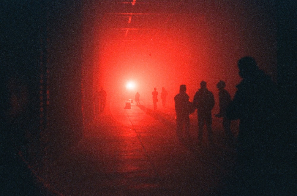 a group of people standing in a tunnel at night