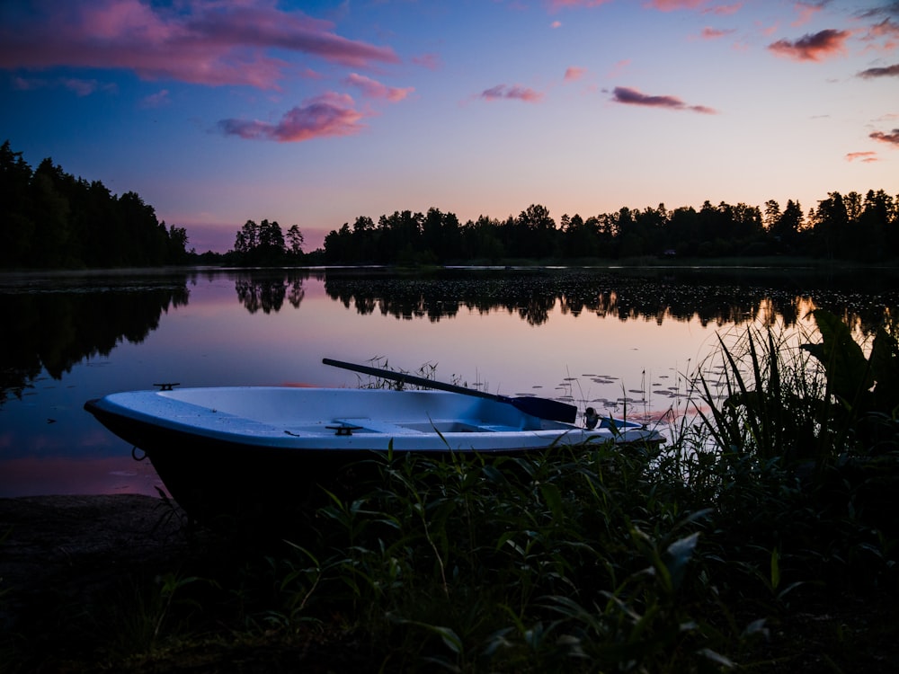 a boat sitting on the shore of a lake