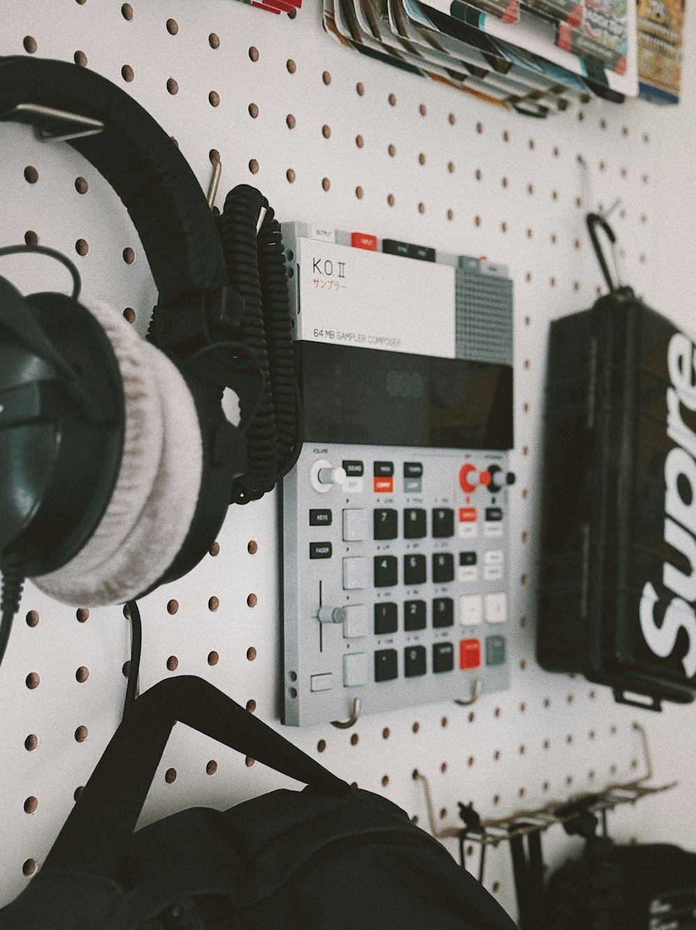 a calculator, headphones, and a bag hanging on a wall