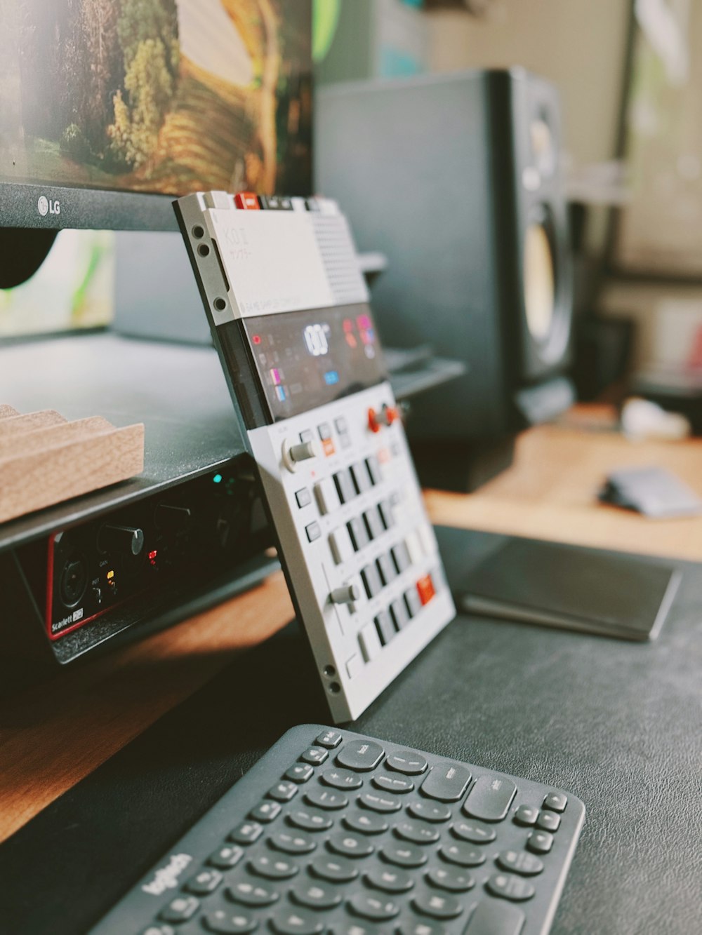 Un teclado sentado encima de un escritorio junto a un monitor