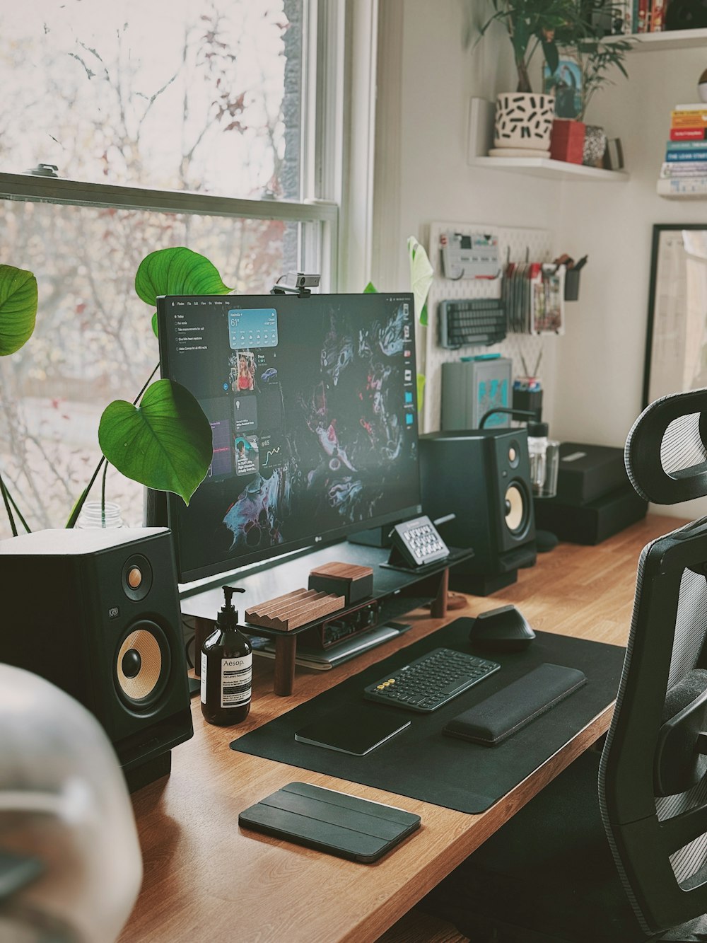 a desk with a computer, speakers and a phone on it