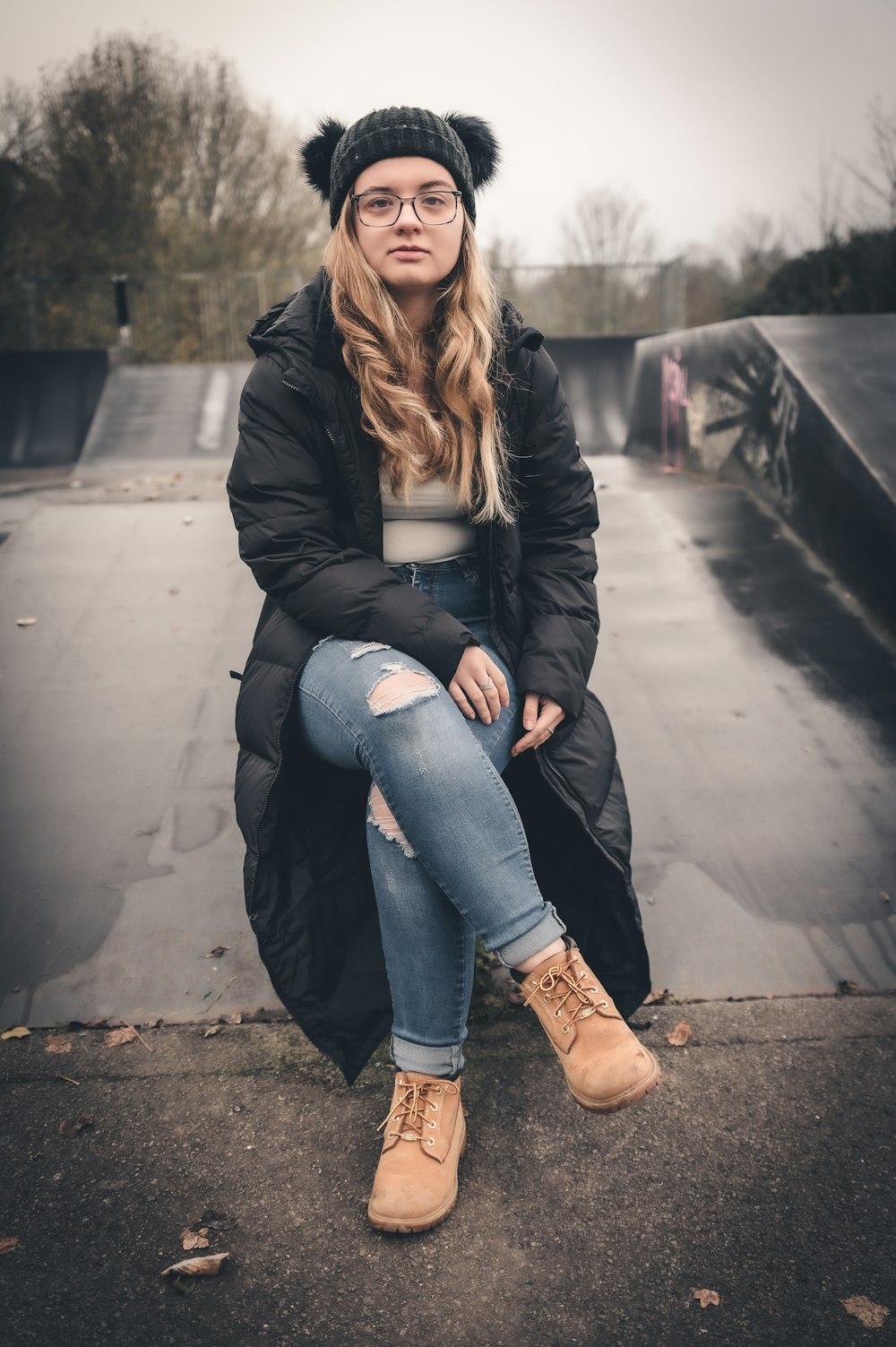 a woman sitting on top of a skateboard ramp