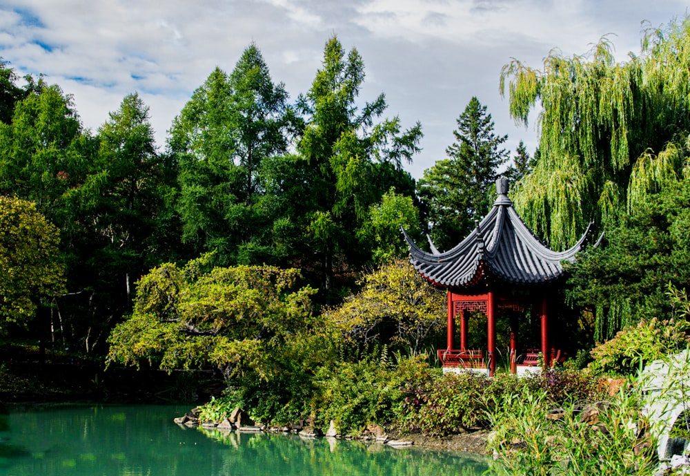 a gazebo in the middle of a pond surrounded by trees