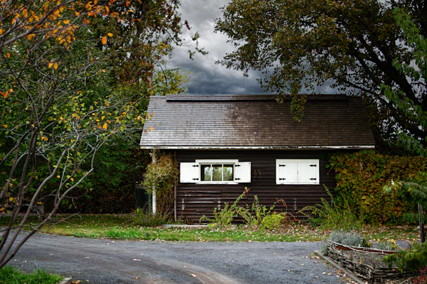 Exterior shot of a cozy cabin-style home featuring dark green trim and natural wood siding.