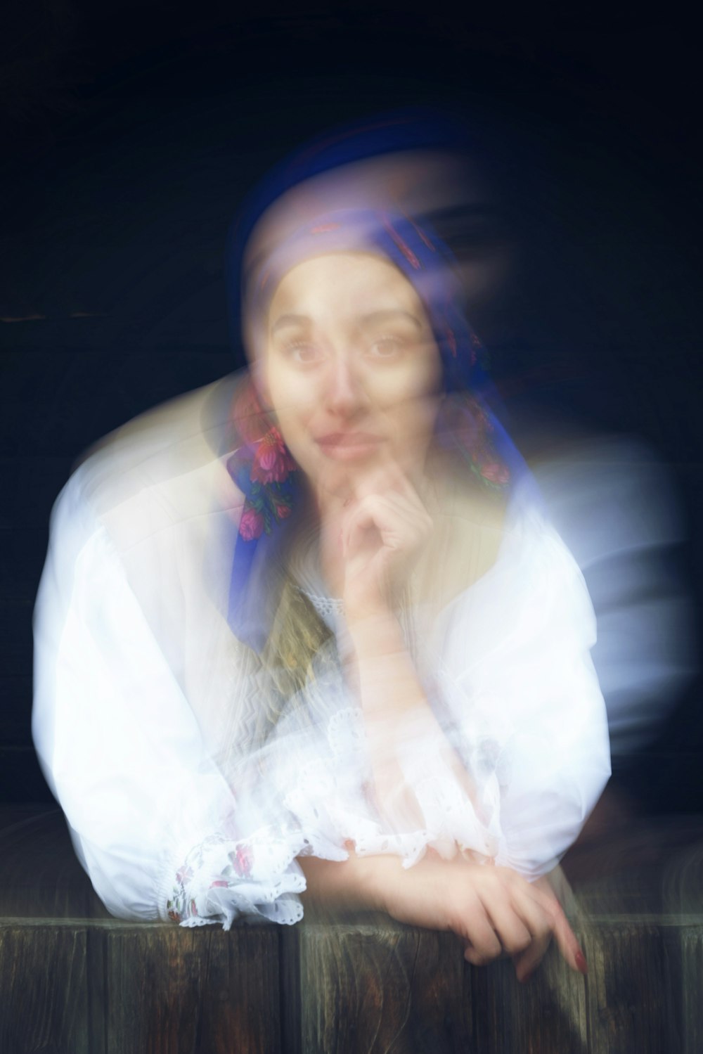 a blurry photo of a woman leaning on a fence