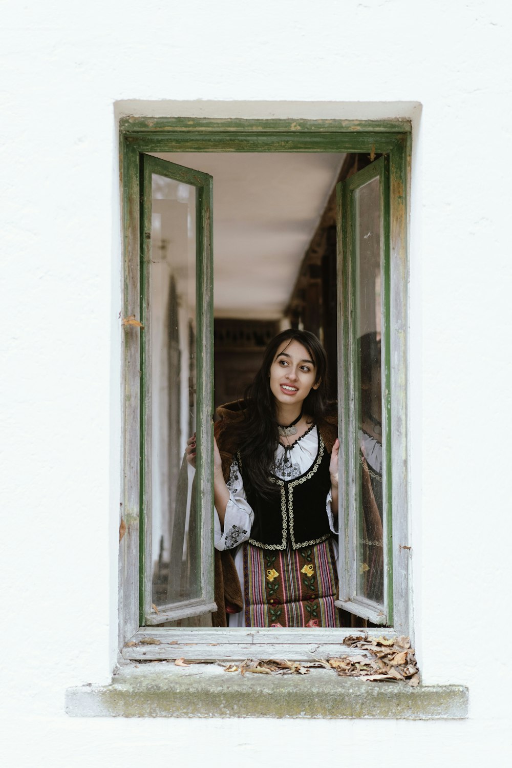 a woman standing in front of a window