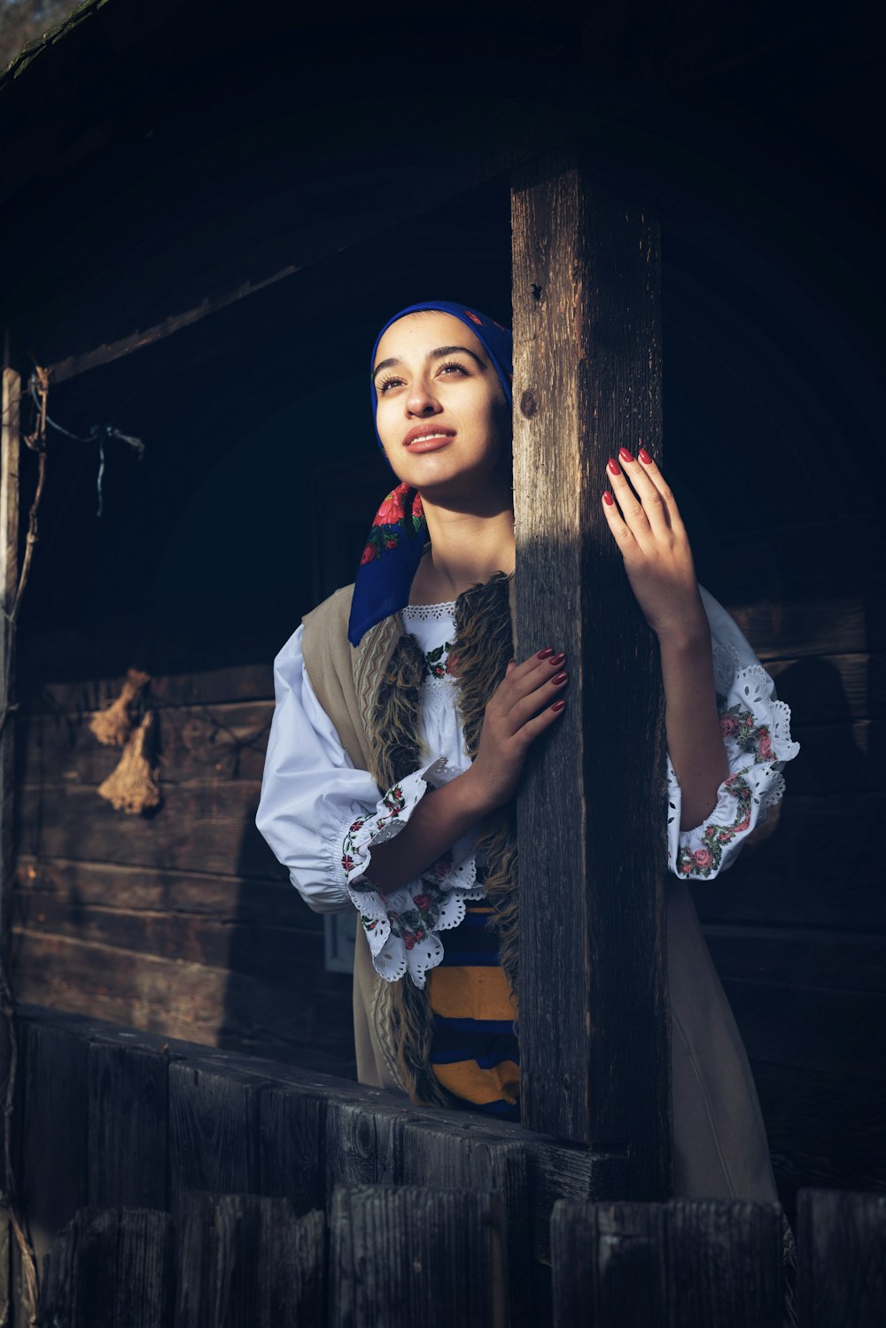 a woman in a pirate costume leaning against a wooden structure