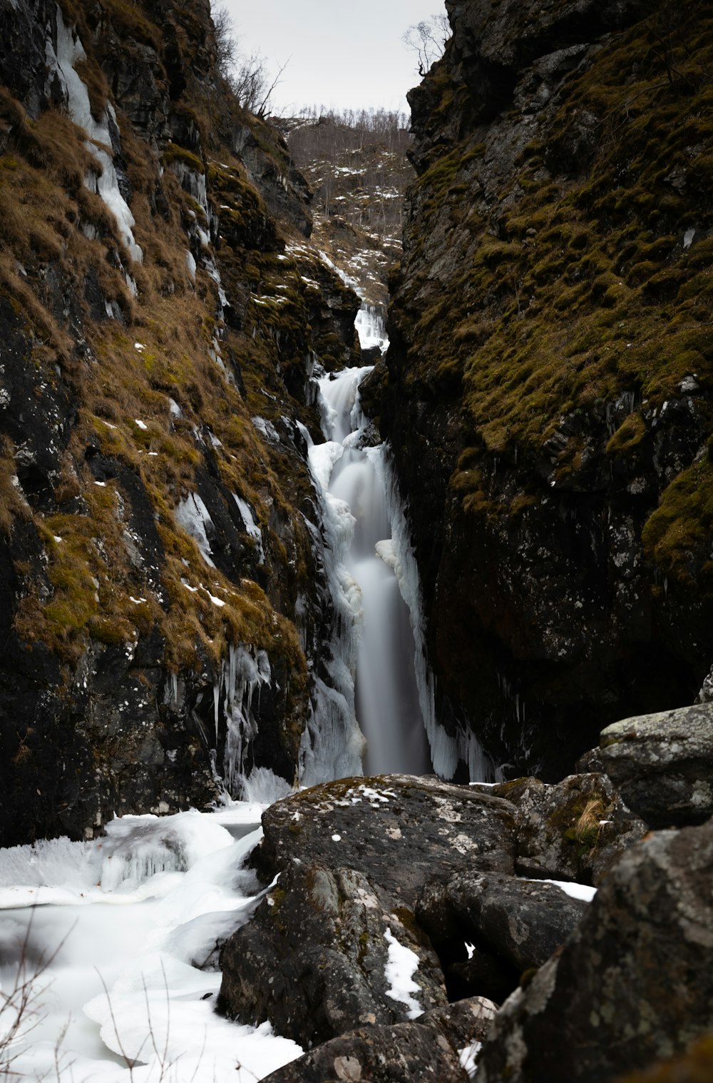 a small waterfall in the middle of a rocky area