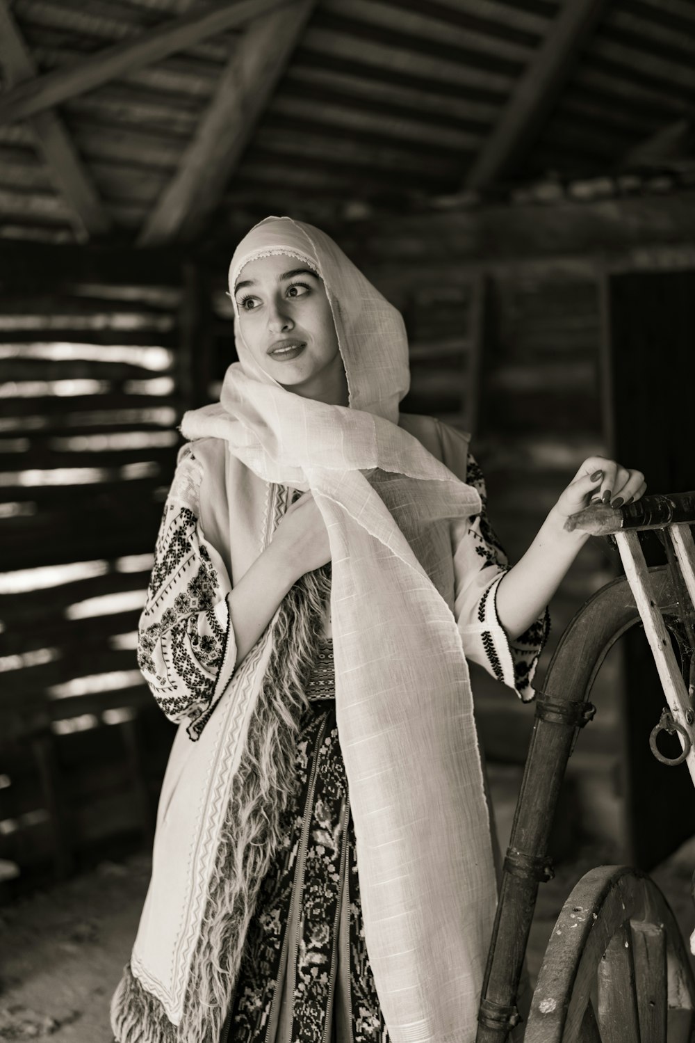 a woman standing next to a bicycle wearing a scarf