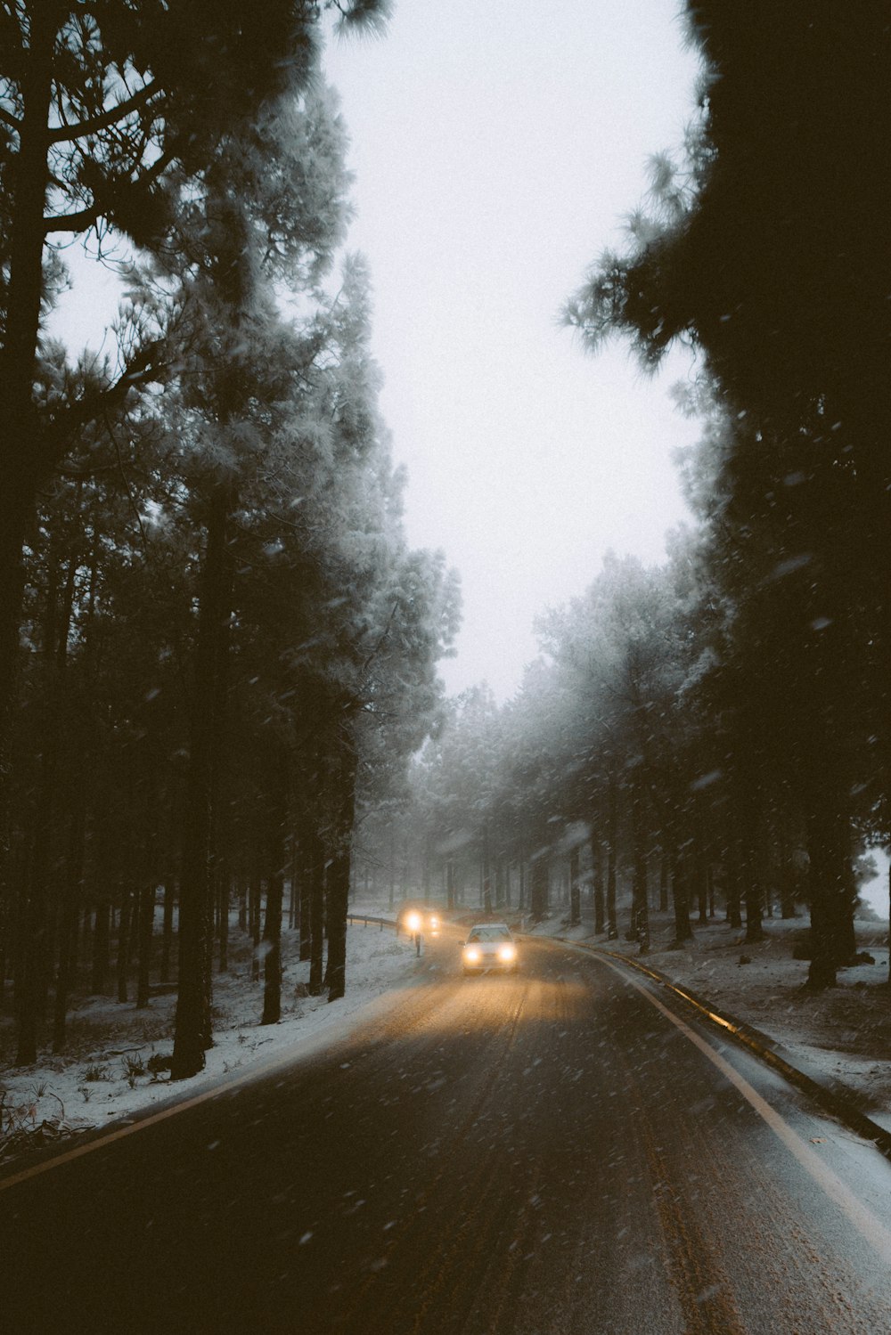 a car driving down a snow covered road