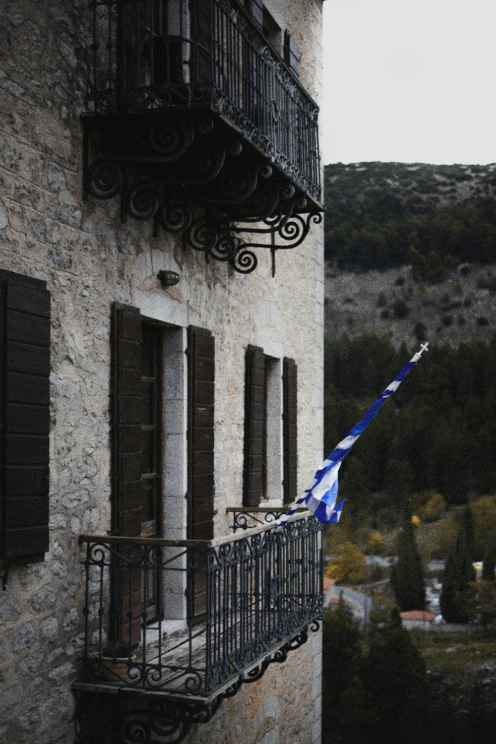 a blue and white flag on a balcony of a building