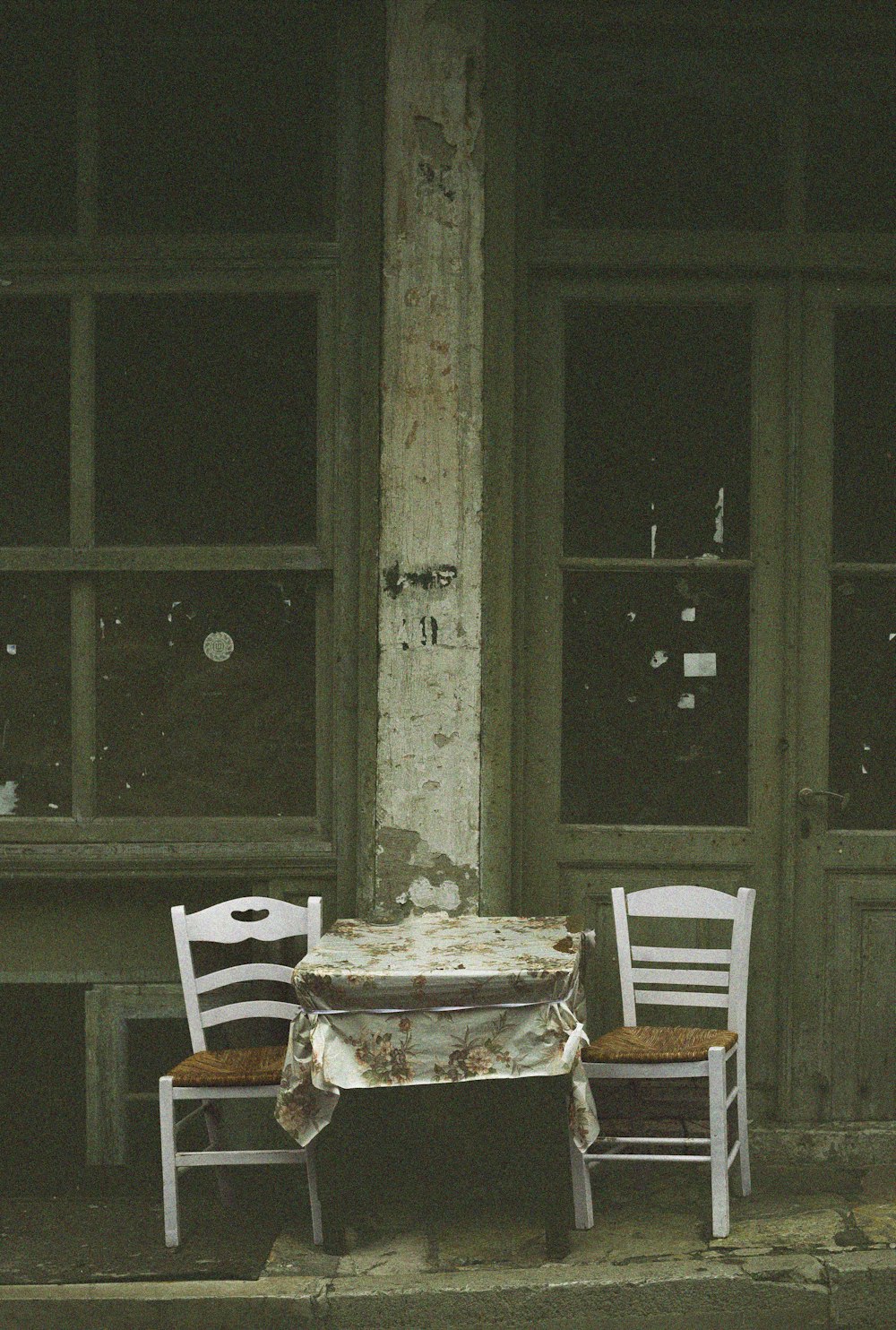 Dos sillas y una mesa frente a un edificio