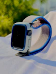 Close-up of a sleek smartwatch with a glowing navy blue strap on a white background.