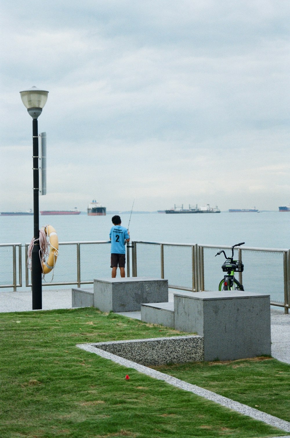 a man standing on a pier next to a body of water