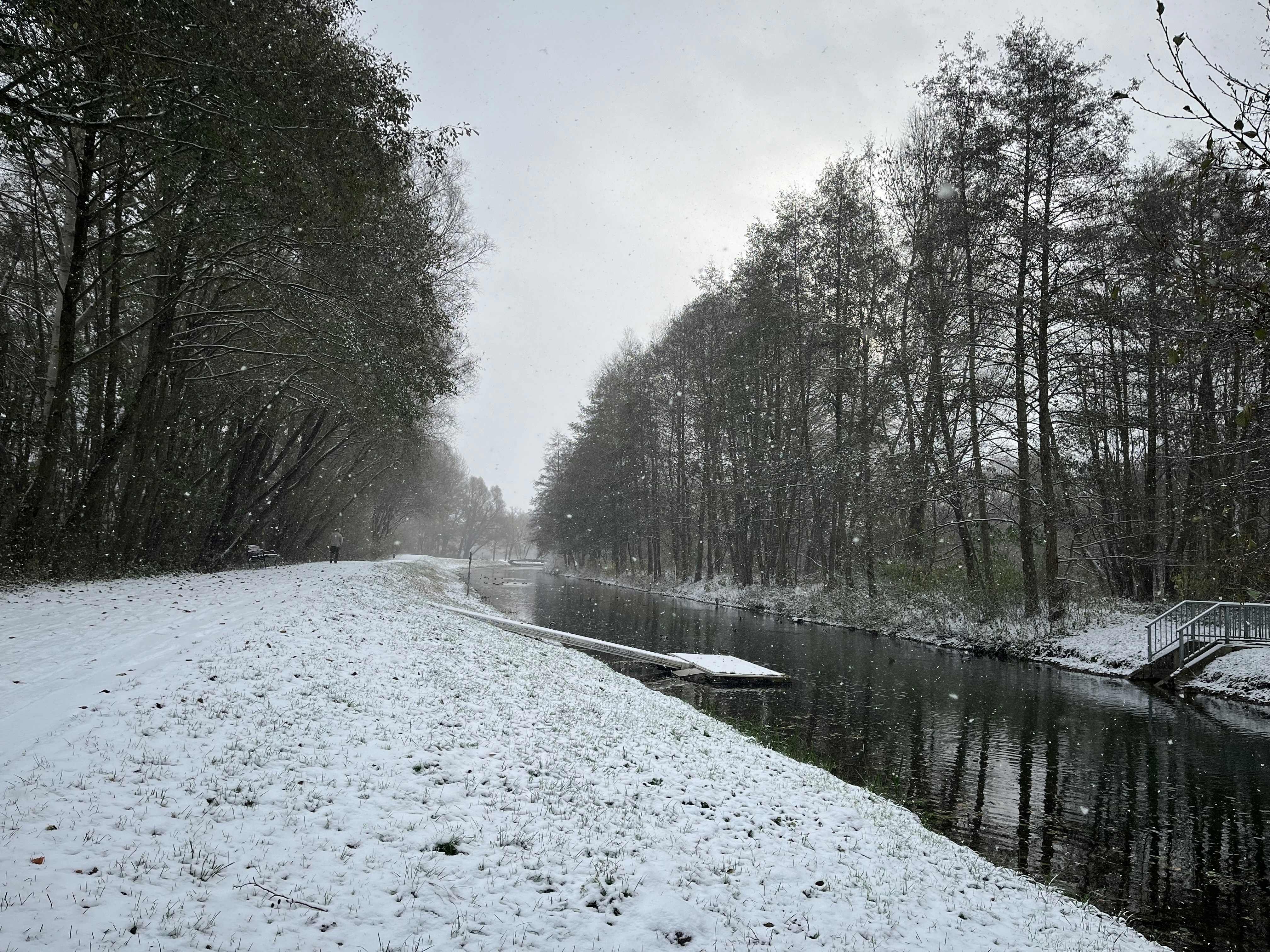 a snow covered road next to a river