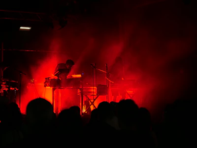 Backstage scene at a vibrant electronic music festival with artists preparing under moody lighting