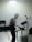 A silhouette of a person engaged in a live electronic music performance, surrounded by various sound equipment such as keyboards, synthesizers, and microphones. The stage is filled with fog, creating a moody and atmospheric ambiance. A strong light from above adds to the dramatic effect.