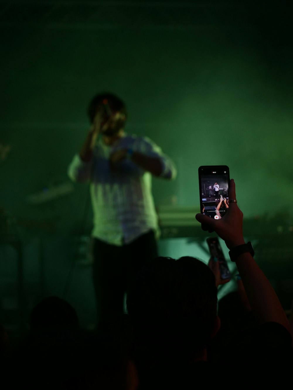 a person taking a picture of a concert with a cell phone