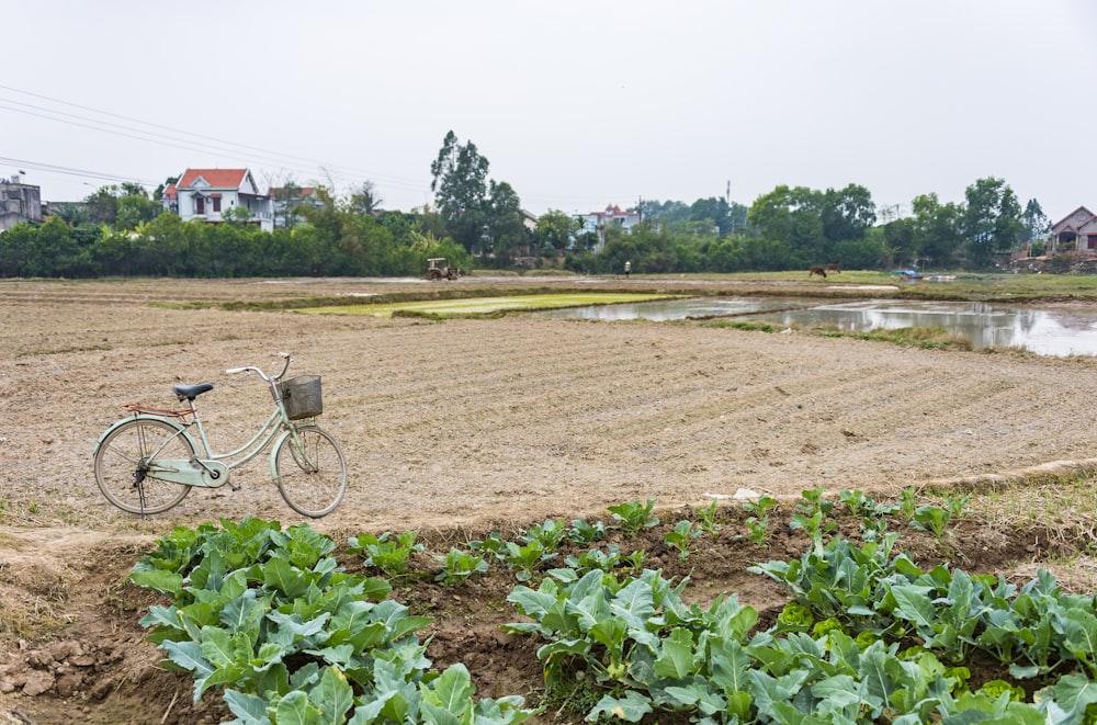 a bike parked next to a plowed field