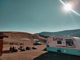 Sleek modern coffee trailer parked at a sunny outdoor market.