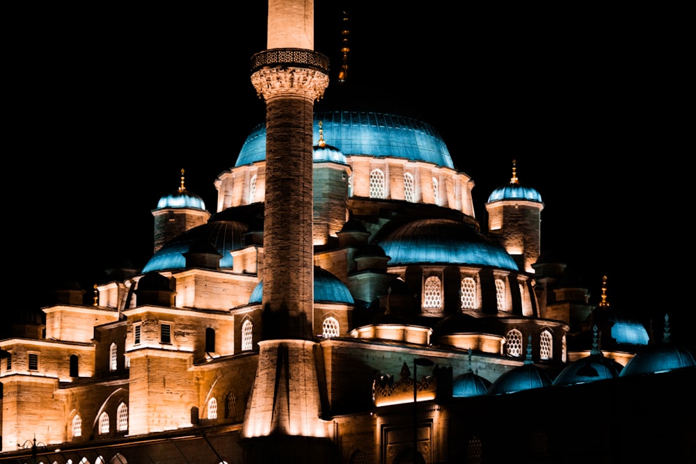 a large building lit up at night with blue domes