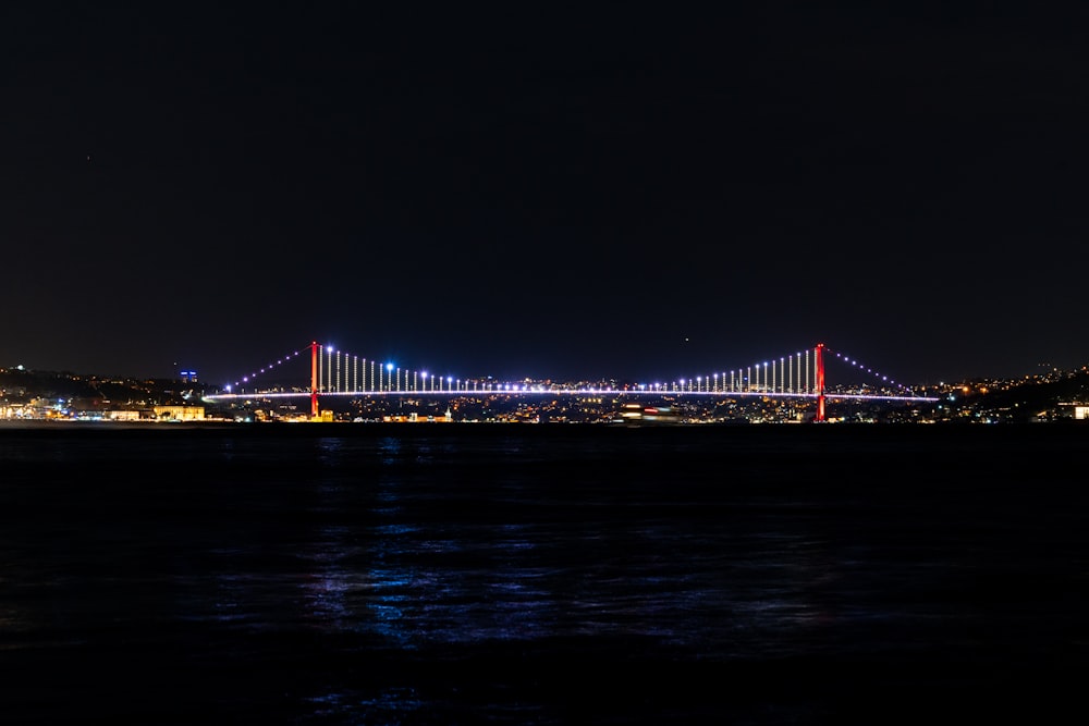 a bridge lit up at night over a body of water