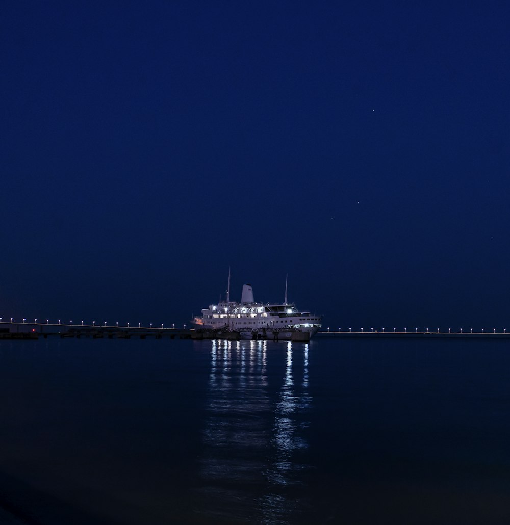 a cruise ship is docked at a pier at night