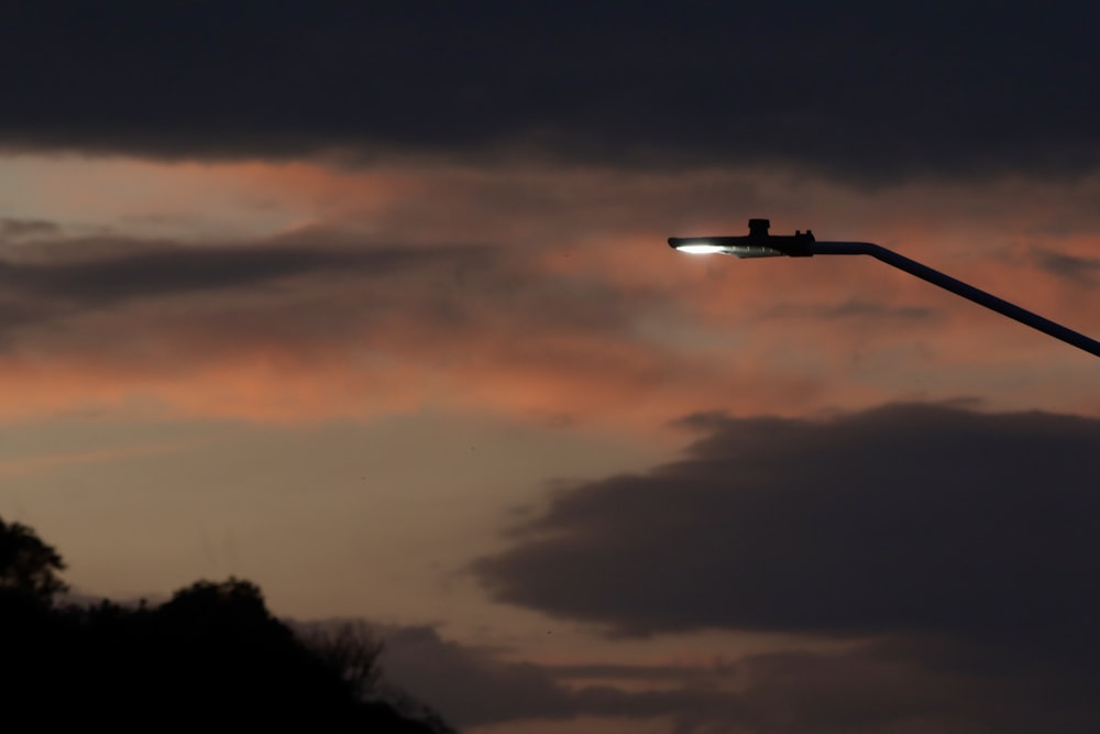 a street light with a cloudy sky in the background