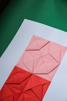 Children happily folding and creating geometric paper shapes at a bright workshop.