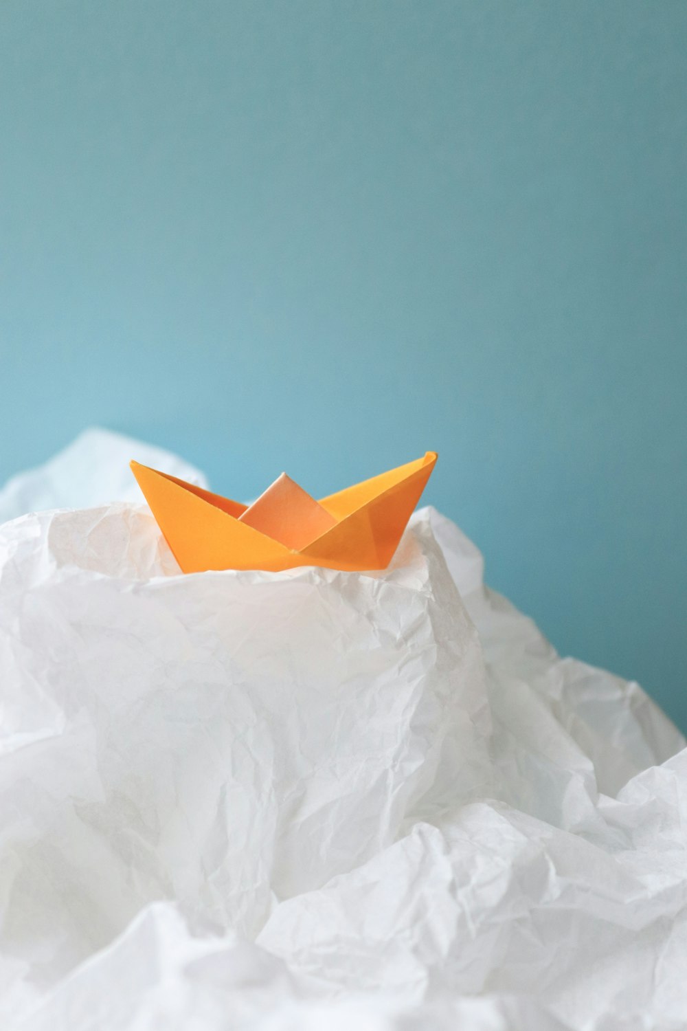 a paper boat floating on top of a pile of paper