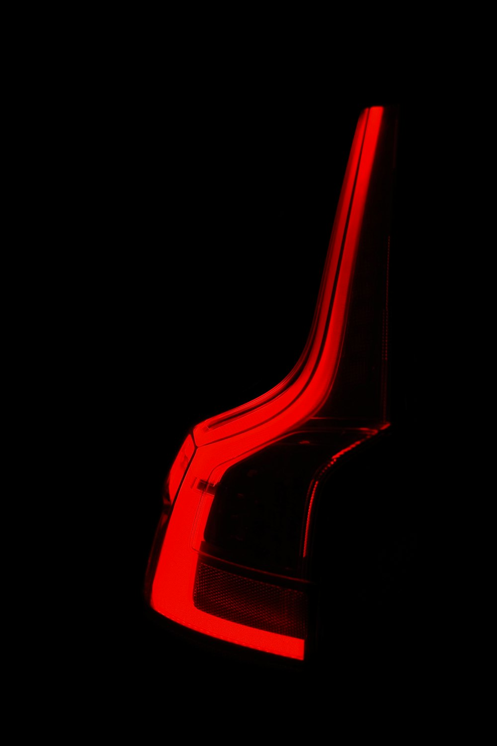 a red chair in the dark with a black background