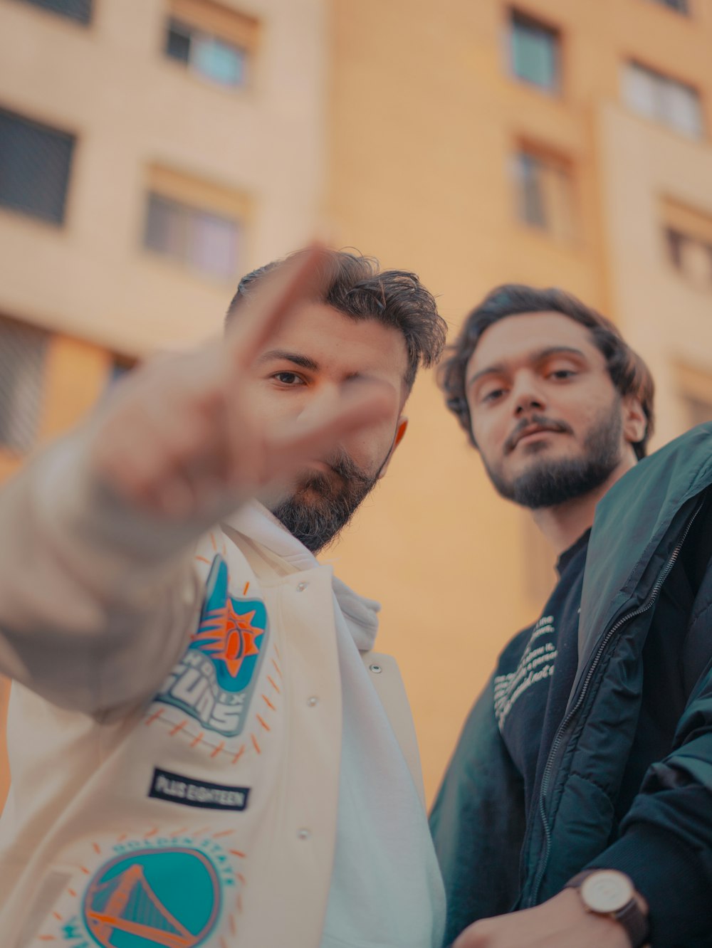 two men standing next to each other in front of a building